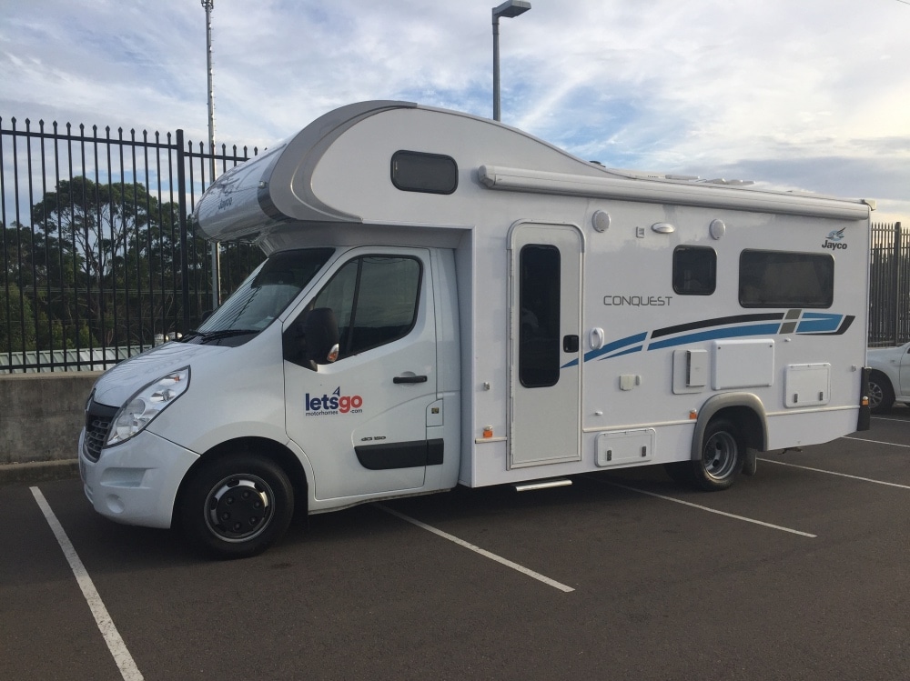 Camping-car de backpackers garé sur le parking d'une station essence sur la cote ouest