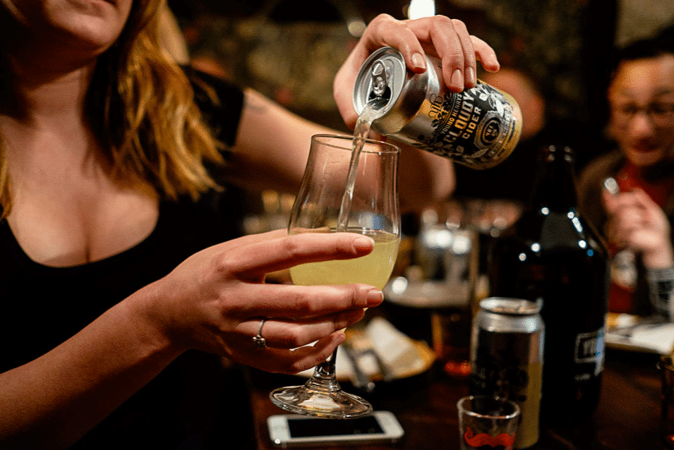 Femme servant une bière dans un bar en Australie après avoir obtenu son certificat RSA.