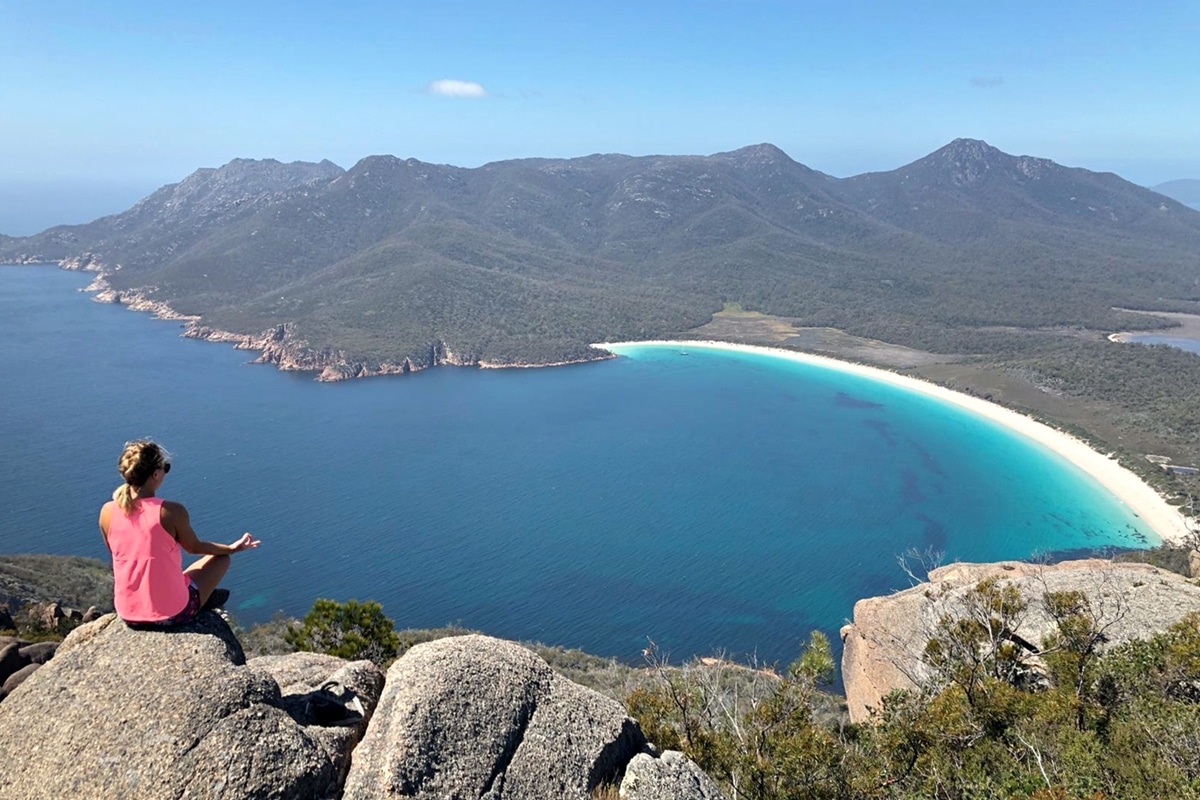 Femme assise à Wineglass Bay - Tasmanie, une des Plus belles plages en Australie