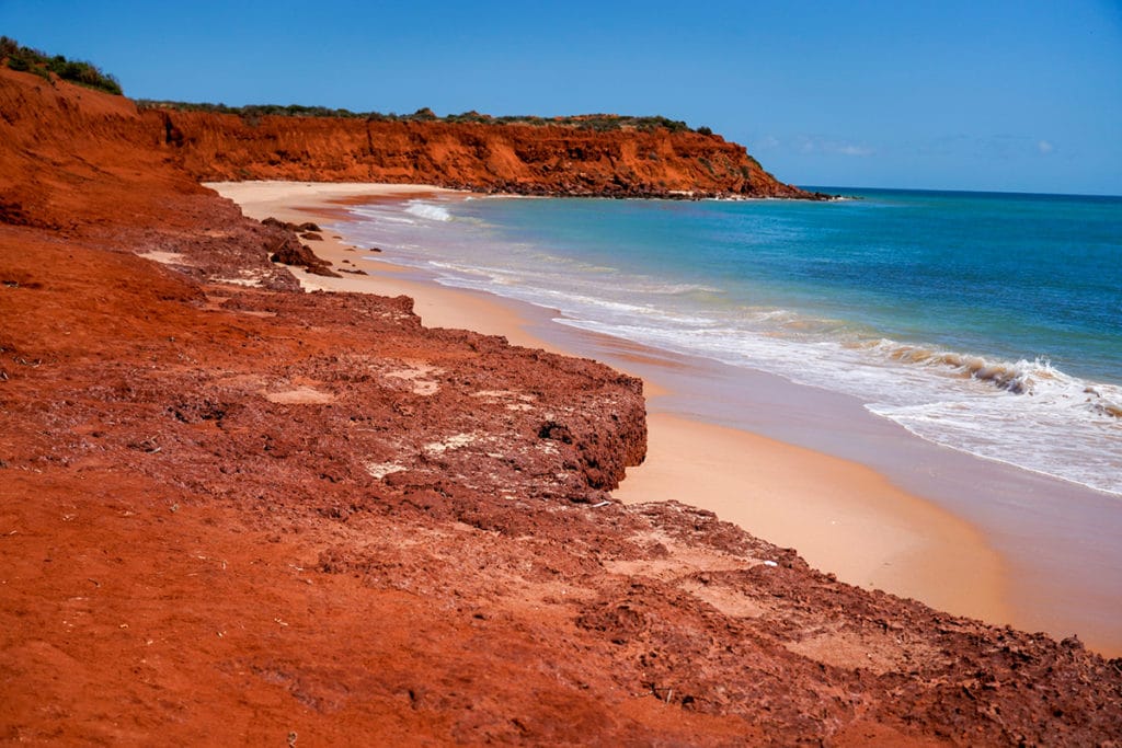 Plage de sable fin et rochers rouges à Shark Bay en Australie