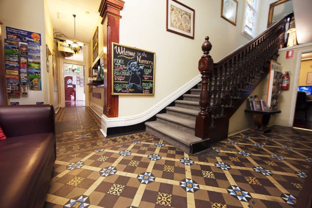 Hall d'entrée d'une auberge de jeunesse avec de beaux escaliers et des informations touristiques pour les backpackers