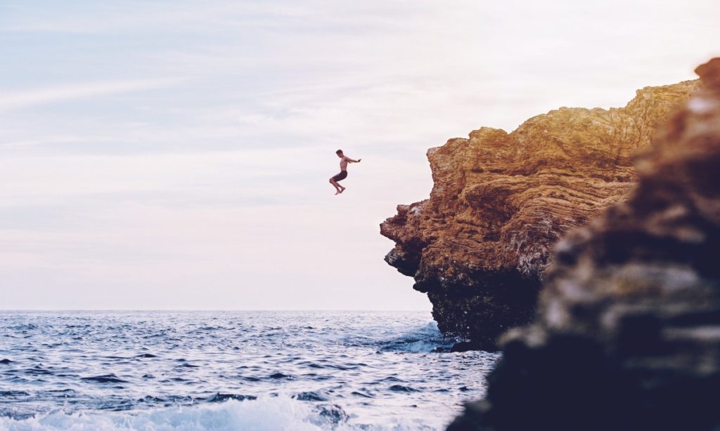 Backpacker qui saute depuis une falaise en Australie car il est parti avec une assurance santé et peut donc tenter de nouvelles expériences.