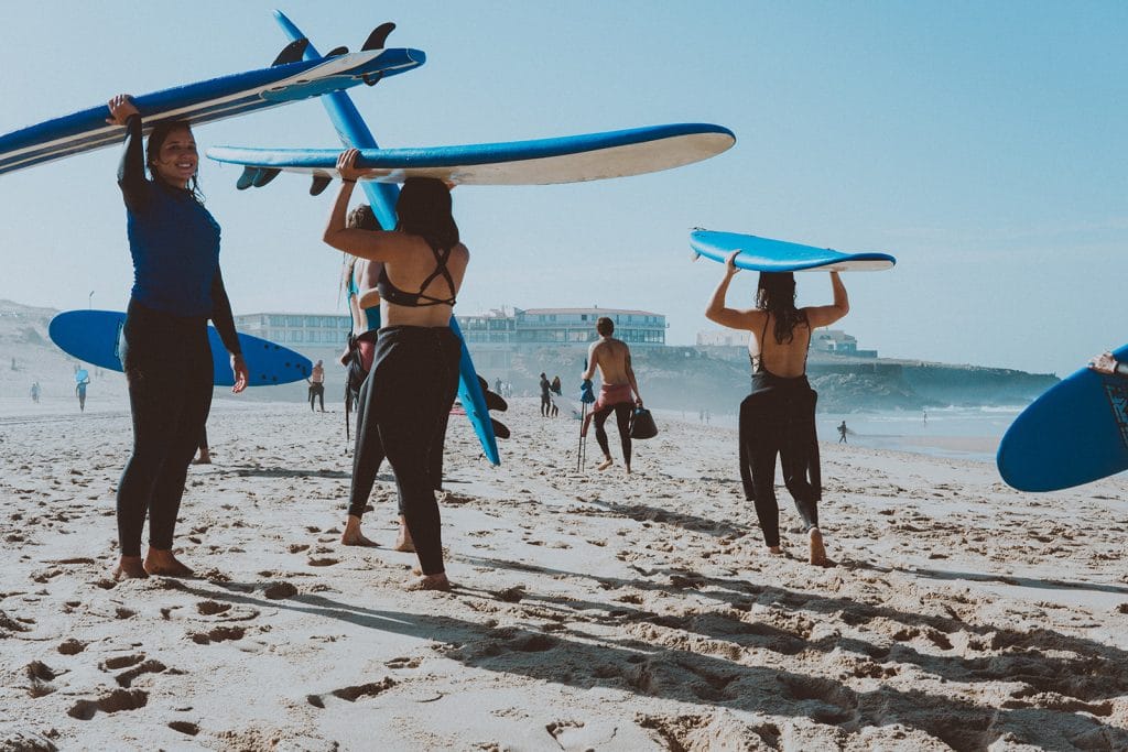 Groupe de personnes prenant un cours de surf car ils sont assurés avec chapka assurance