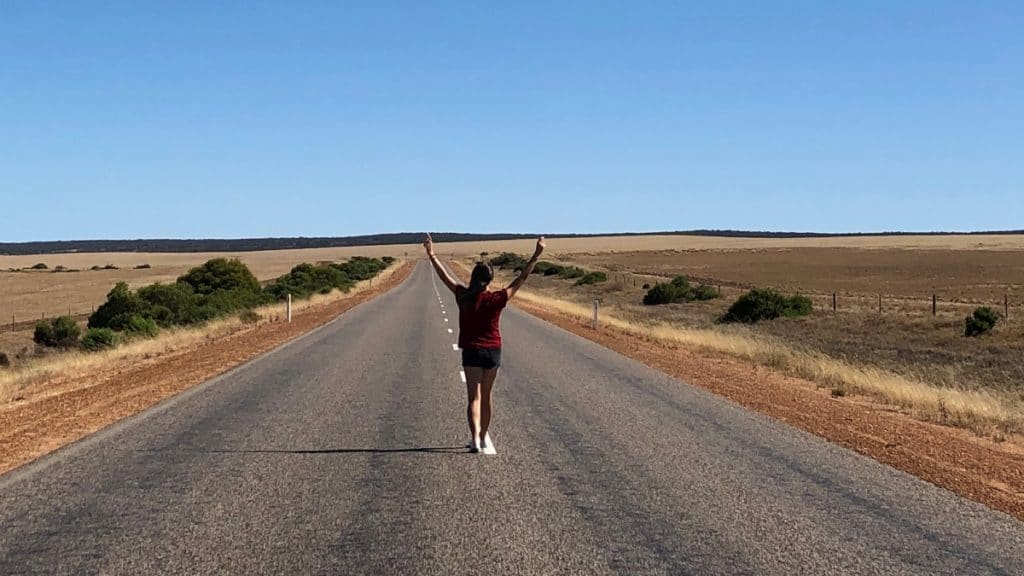 femme marchant sur la route dans des paysages désertiques